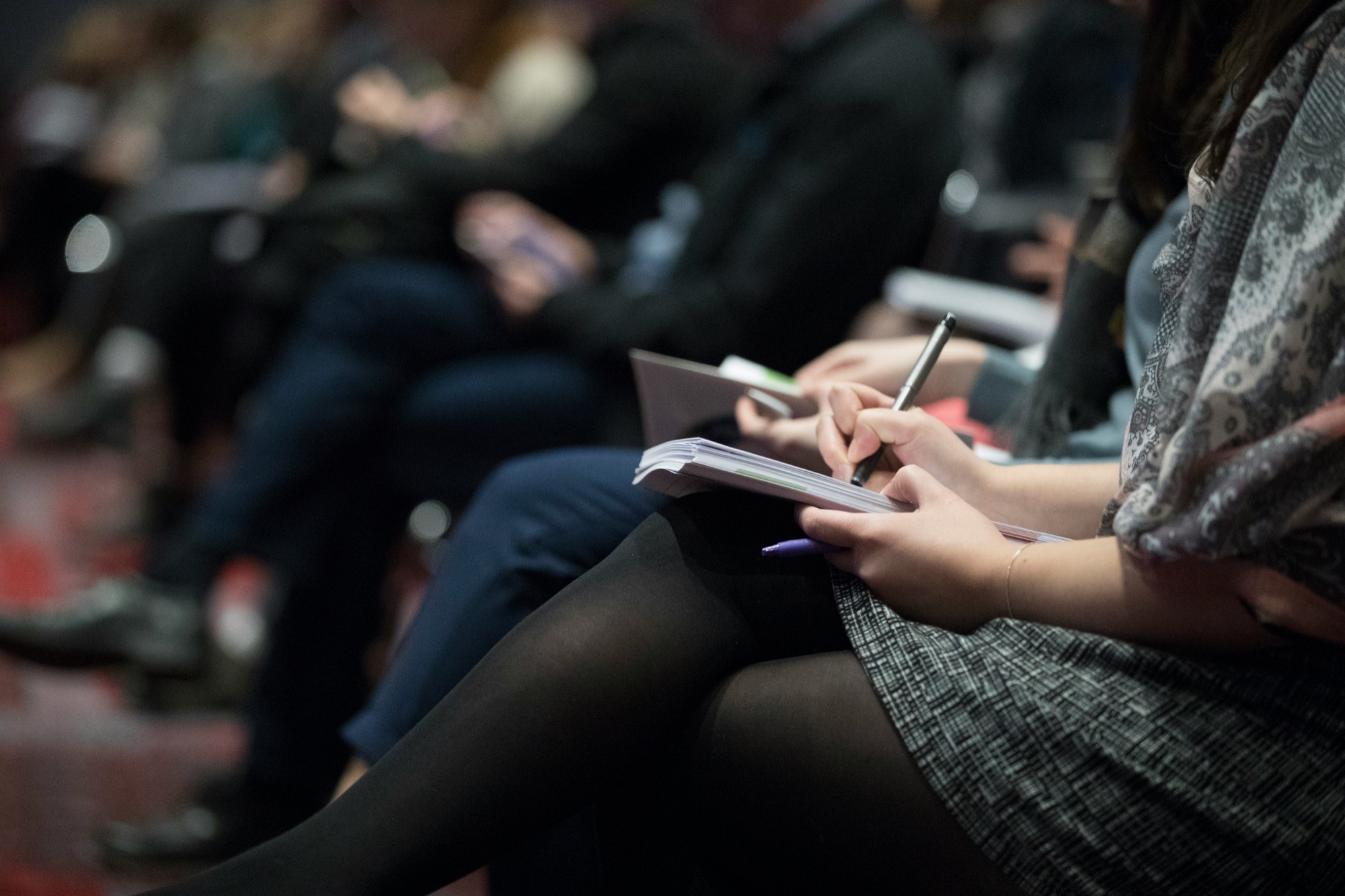 Konferenzteilnehmer beim Ausfüllen von Anmeldeformularen